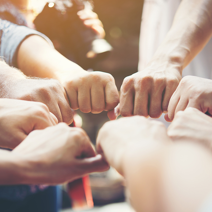 Close up of young people putting their hands together. Team with